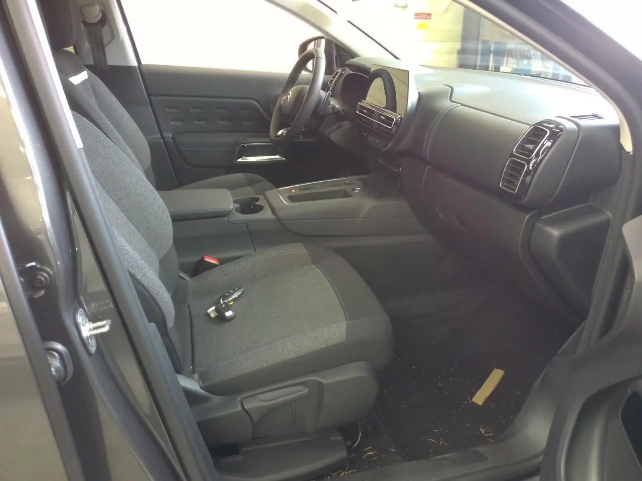 Vue intérieure côté conducteur du Citroën C5 Aircross gris platinium, montrant sièges et tableau de bord moderne.