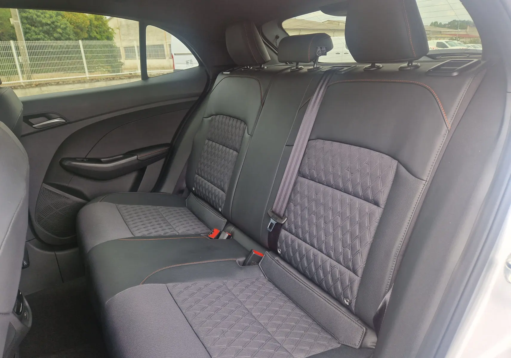 Vue intérieure côté droit des sièges arrière en tissu et cuir noir avec surpiqûres orange du MG3 Cosmic Silver 2026.