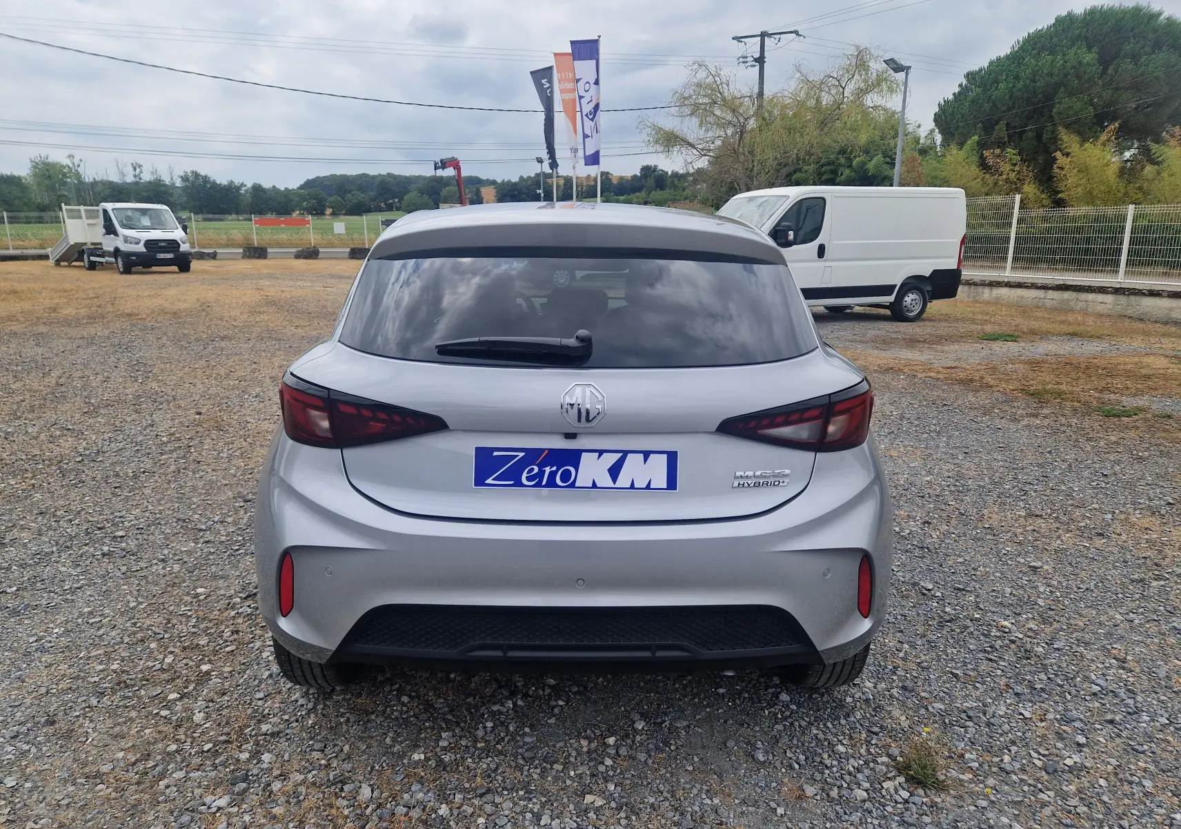 Vue arrière d'une MG3 1.5L Hybrid+ 195CH Luxury en Cosmic Silver Metal, avec logo MG et feux arrière foncés.