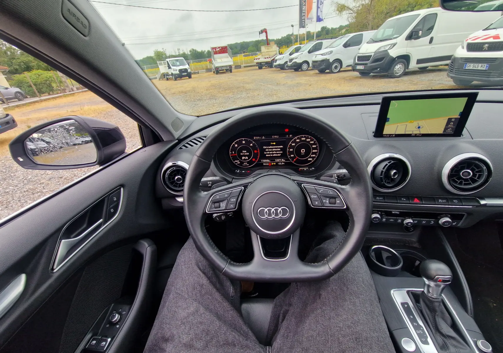 Vue intérieure de l'Audi A3 Sportback noire 2019, tableau de bord avec volant multifonction et écran GPS central.