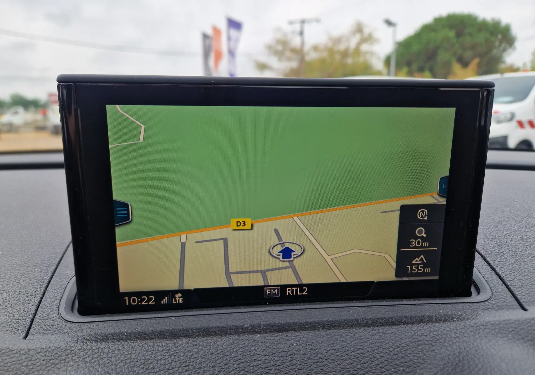 Écran de navigation GPS intégré au tableau de bord d'une Audi A3 Sportback noire, vue intérieure frontale.