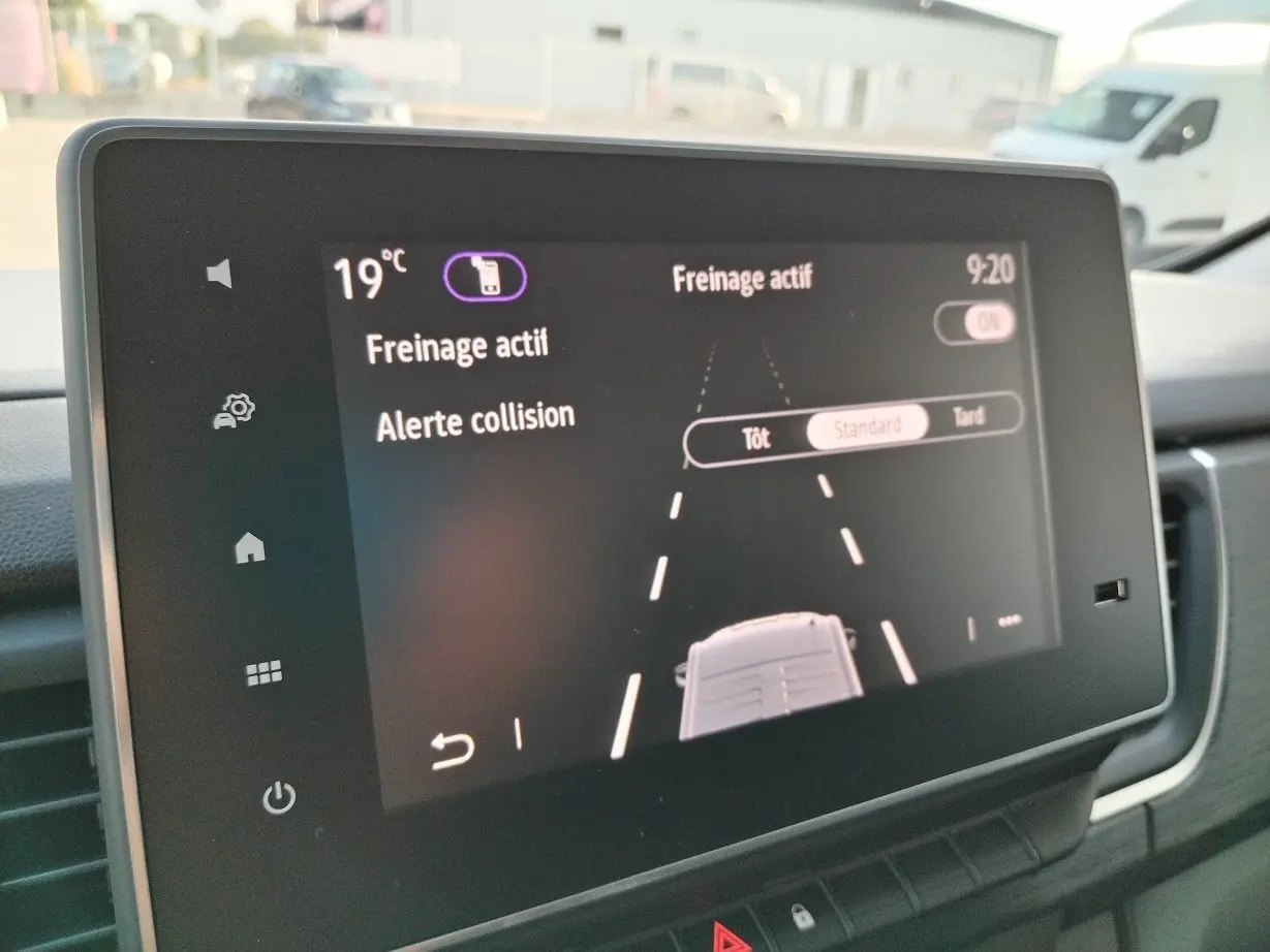 Écran tactile intérieur du Nissan Primastar 2025 montrant l'activation du freinage actif et alerte collision.