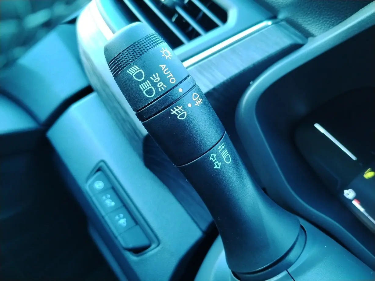 Gros plan sur la commande des phares et clignotants dans l'habitacle du Nissan Primastar blanc 2025.