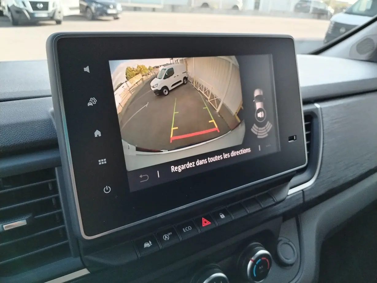 Écran tactile intérieur montrant la caméra de recul du Nissan Primastar blanc, vue depuis le tableau de bord côté droit.