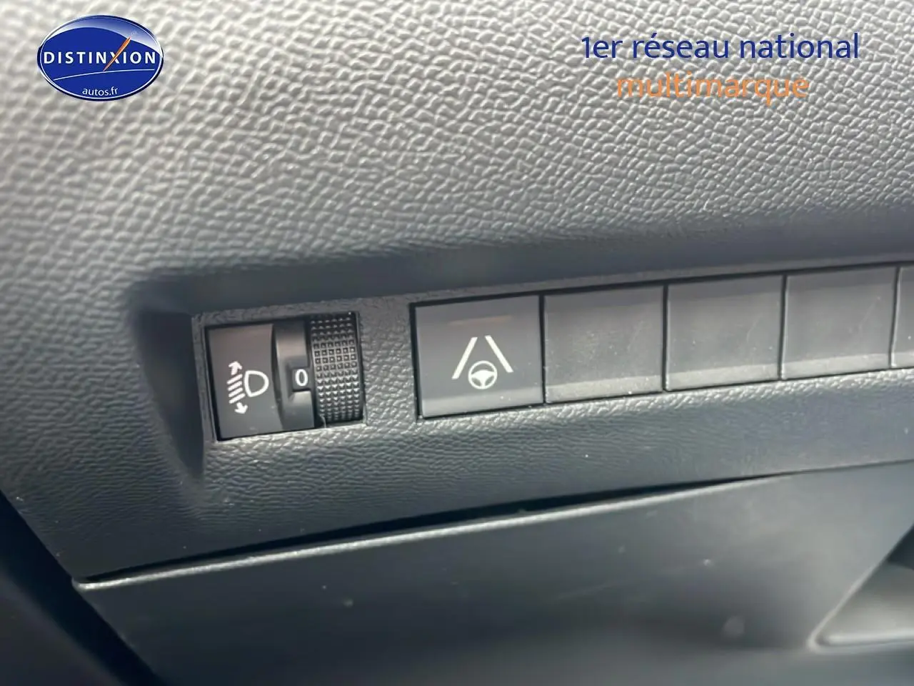 Gros plan sur les commandes d'assistance à la conduite dans un Peugeot 2008 E-136 allure gris sélénite, intérieur noir.