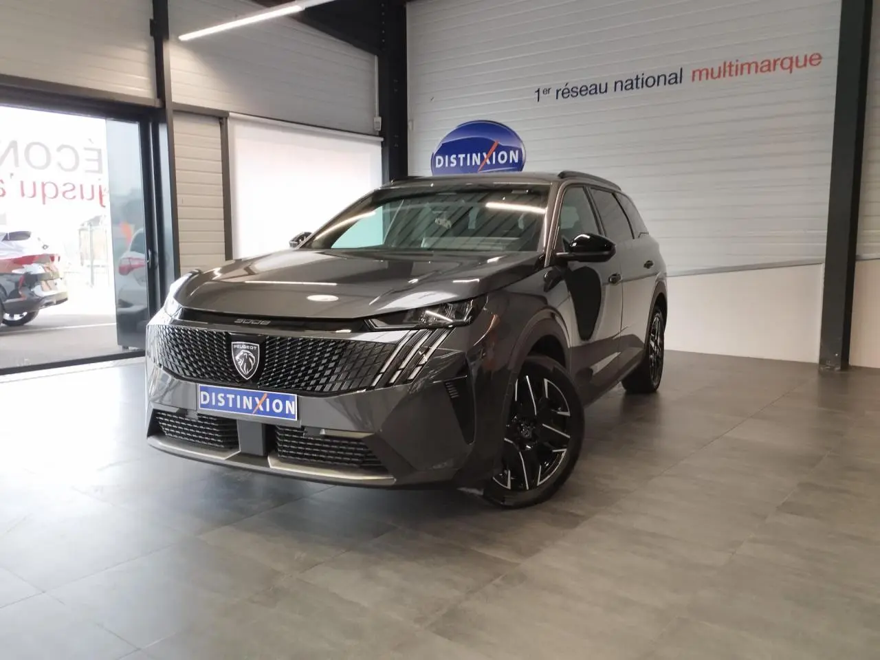 Peugeot 5008 gris titanium en 3/4 avant droit, avec calandre noire et jantes alliage 19 pouces diamantées.