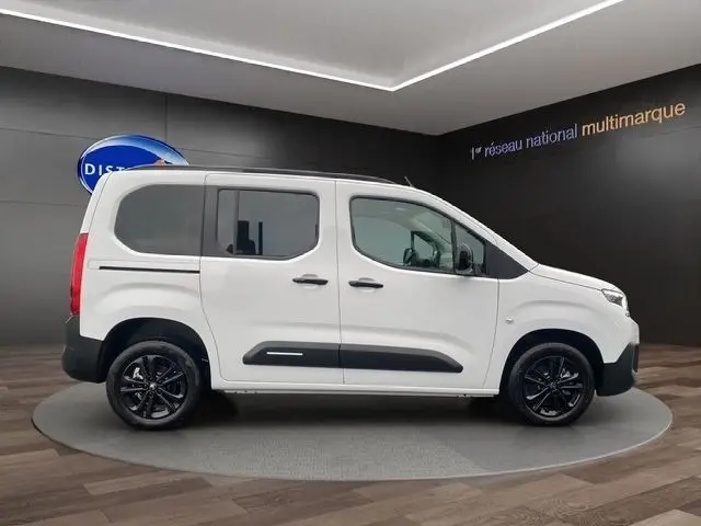Vue latérale droite d'un Citroën Berlingo blanc 2025 avec jantes noires et protections latérales noires.