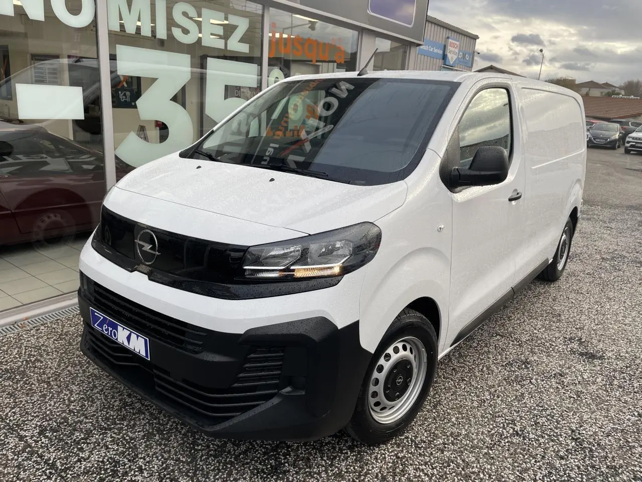 Vue 3/4 avant droit d’un utilitaire Opel Vivaro blanc avec calandre noire et jantes tôles grises.