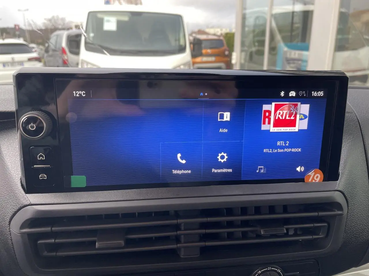 Écran tactile 10 pouces affichant la radio RTL2 dans l'habitacle d'un Opel Vivaro blanc, vue frontale rapprochée.