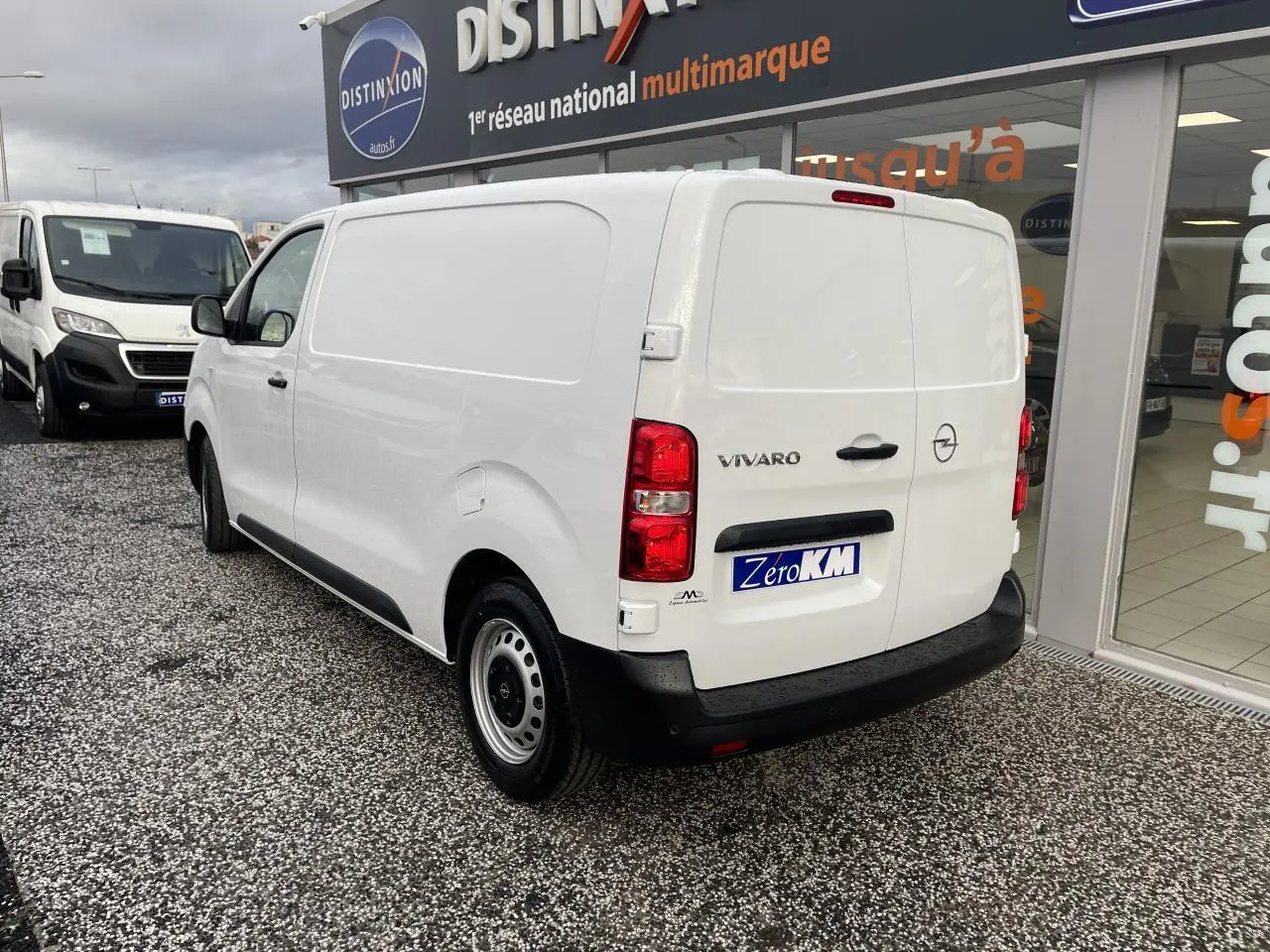 Vue 3/4 arrière droite d'un Opel Vivaro blanc avec portes arrière battantes et jantes tôles grises.