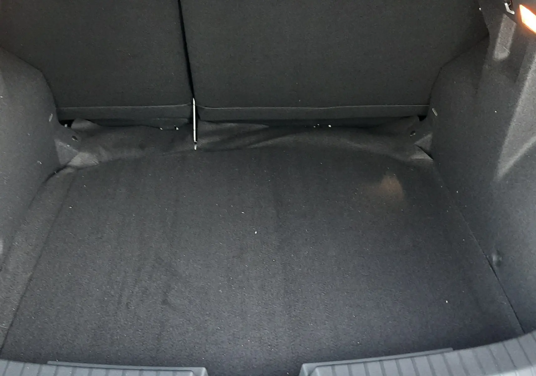 Coffre spacieux du Dacia Duster 2025 en version 1.6 Hybrid 140ch Extreme, vue intérieure arrière avec revêtement noir.