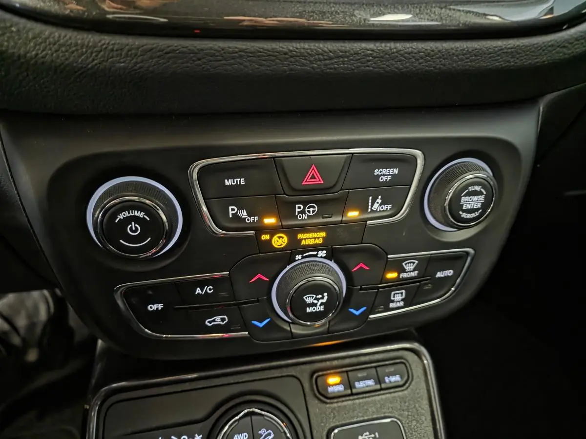 Tableau de bord du Jeep Compass 2020, détail des commandes de climatisation et aides à la conduite en noir.