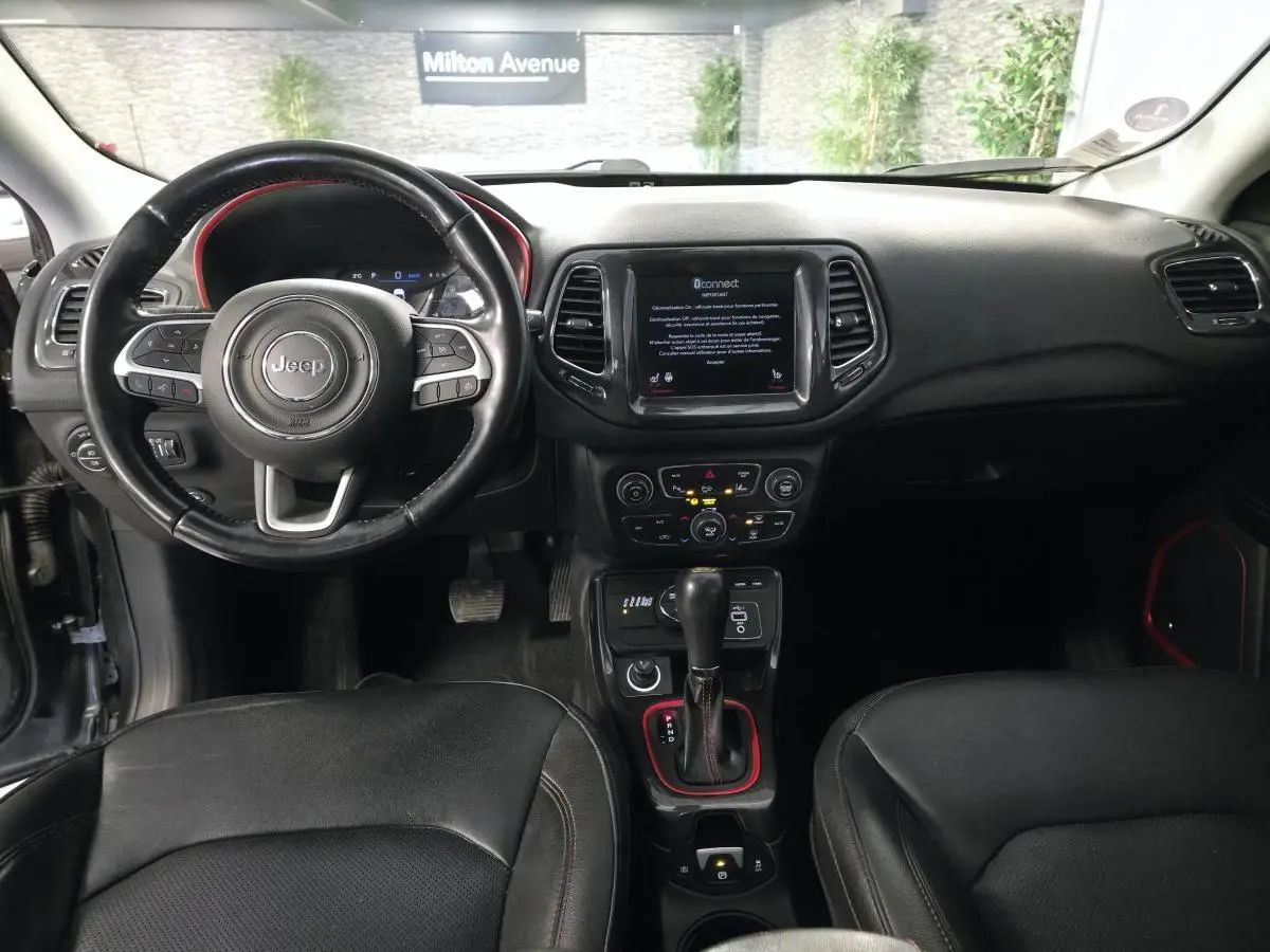 Intérieur noir du Jeep Compass 2020 avec volant cuir, console centrale et écran tactile au centre du tableau de bord.