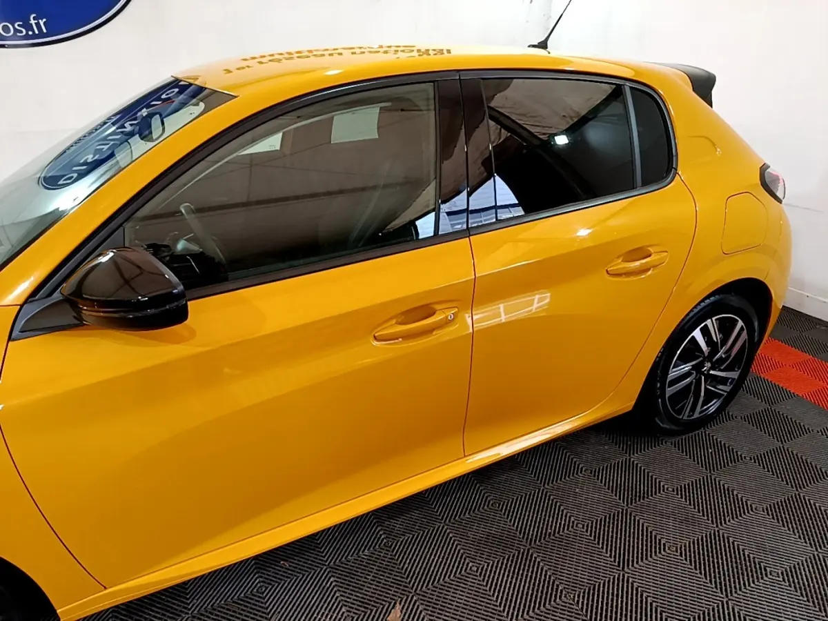 Profil latéral gauche d'une Peugeot 208 jaune vif, avec rétroviseur noir et jantes alliage modernes.