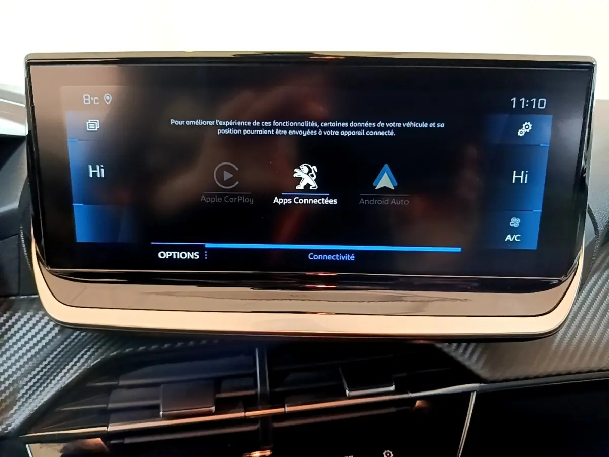 Écran tactile central de la Peugeot 208 jaune 2023 affichant les options Apple CarPlay et Android Auto.