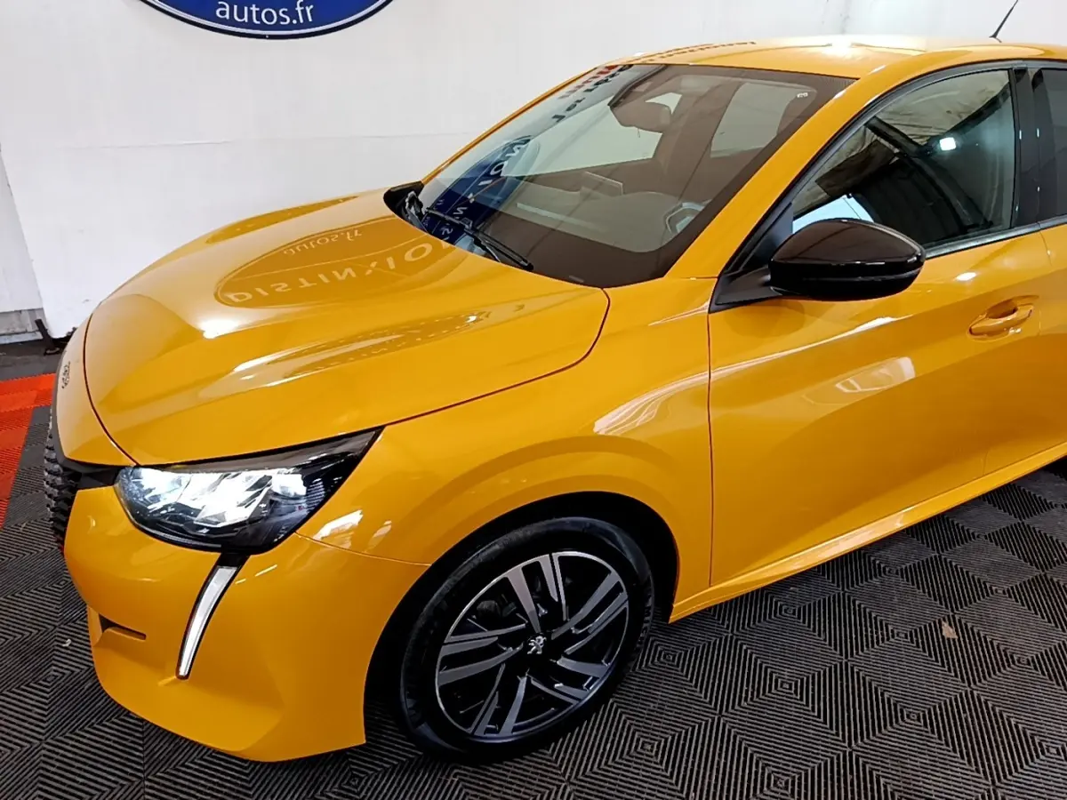 Vue 3/4 avant droit d'une Peugeot 208 jaune vif avec feux LED et jantes alliage noires.