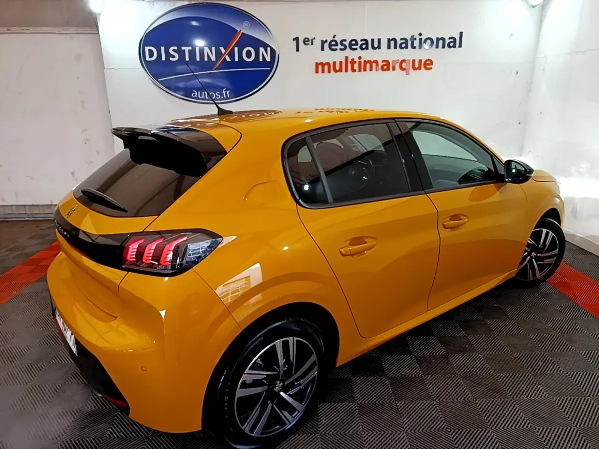 Vue 3/4 arrière droite d'une Peugeot 208 jaune 2023 avec feux LED et jantes alliage distinctives.