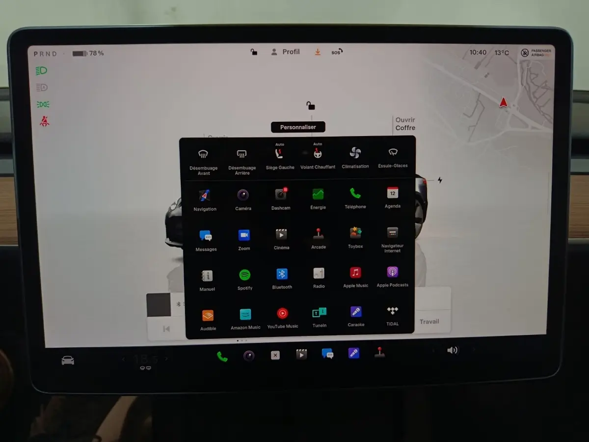 Écran tactile central de 15 pouces de la Tesla Model 3 gris foncé, affichant le menu des applications en intérieur.