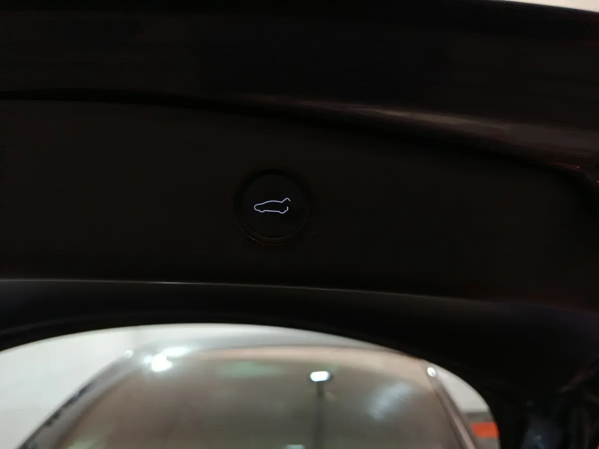 Bouton d'ouverture du coffre intérieur noir sur Tesla Model 3 Grande Autonomie gris foncé, vue depuis l'arrière ouvert.