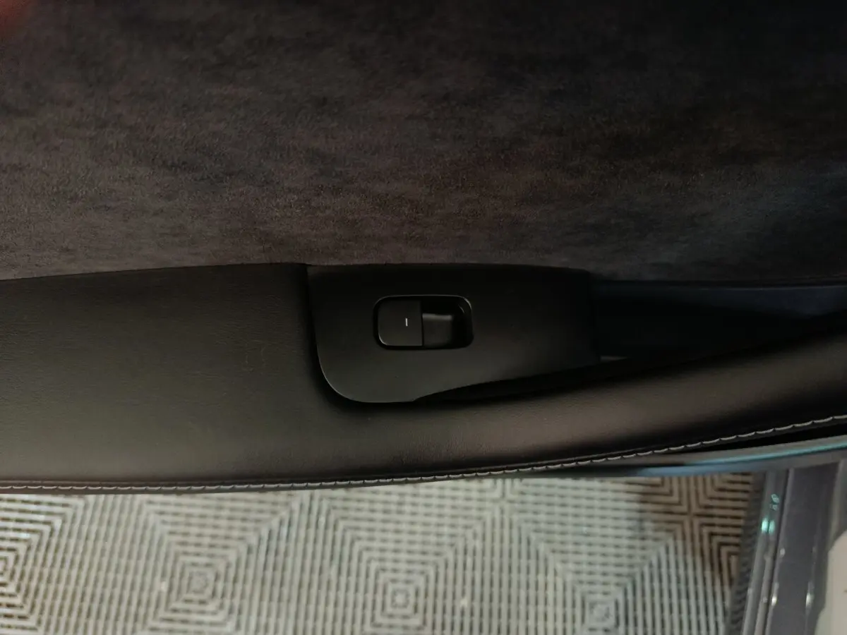 Gros plan sur la commande de verrouillage de porte côté conducteur d’une Tesla Model 3 gris foncé.