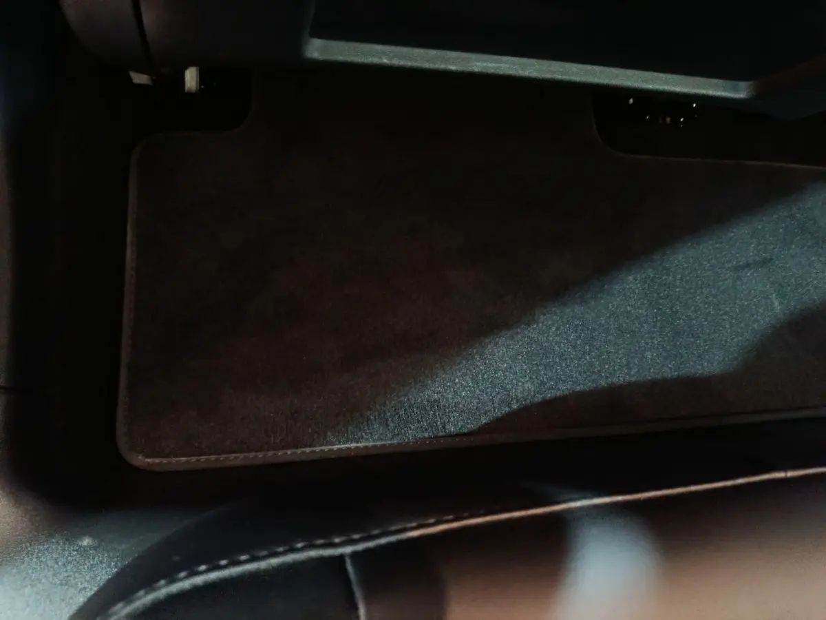 Vue intérieure du tapis de sol avant noir dans une Tesla Model 3 Grande Autonomie gris foncé de 2022.