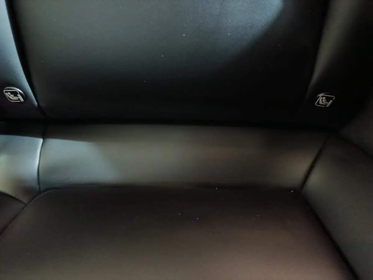 Gros plan sur la banquette arrière en cuir noir de la Tesla Model 3 Grande Autonomie 2022, avec indications Isofix visibles.