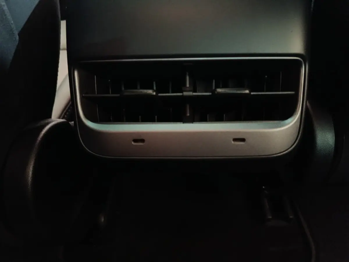 Détail de la sortie d'air arrière noire dans l'habitacle d'une Tesla Model 3 Grande Autonomie gris foncé 2022.