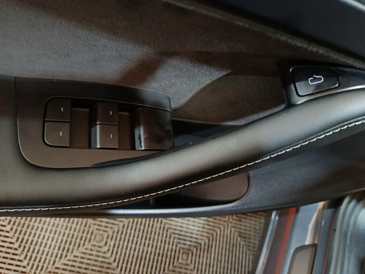 Détail de la commande des vitres sur la porte côté conducteur d’une Tesla Model 3 gris foncé, finition 2022.