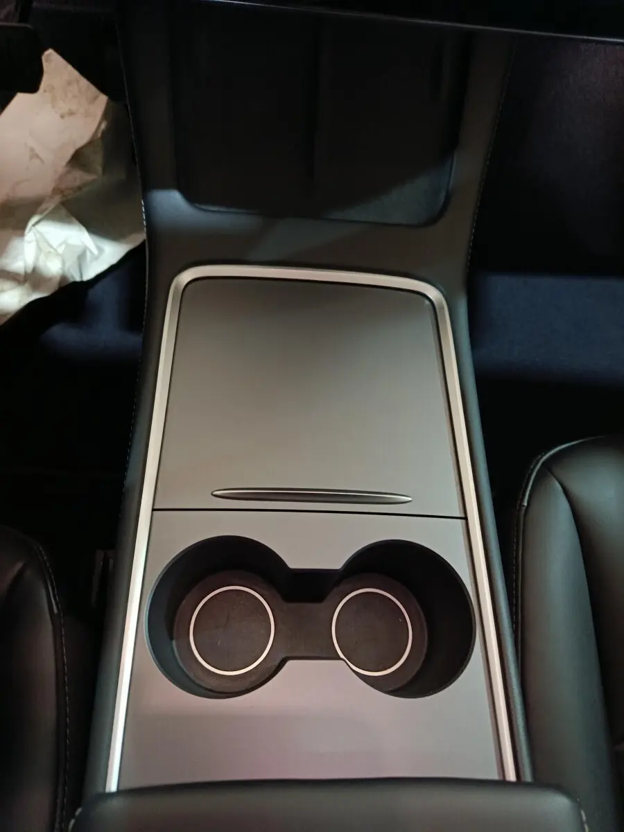 Vue plongeante sur la console centrale grise avec porte-gobelets du Tesla Model 3 Grande Autonomie 2022.