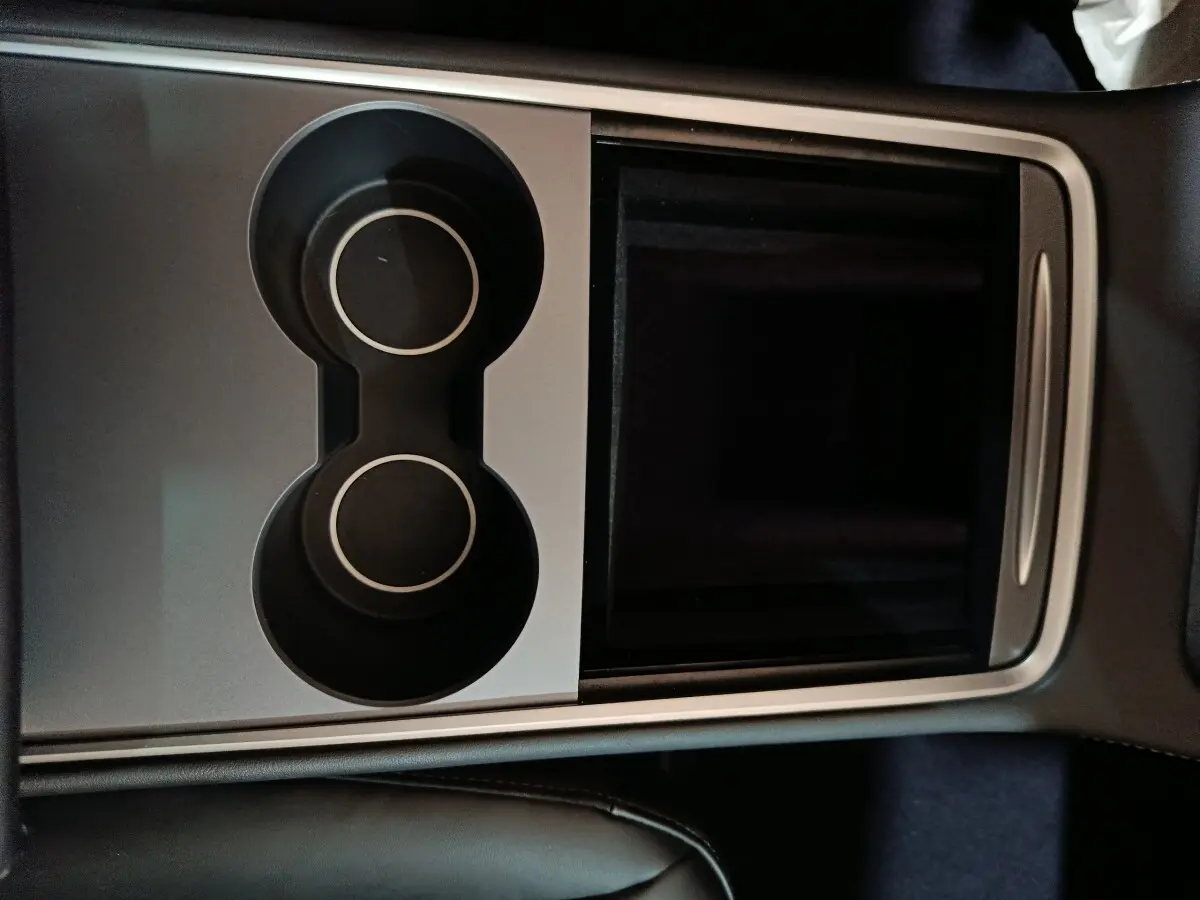 Vue plongeante sur la console centrale noire et grise avec porte-gobelets de la Tesla Model 3 Grande Autonomie 2022.