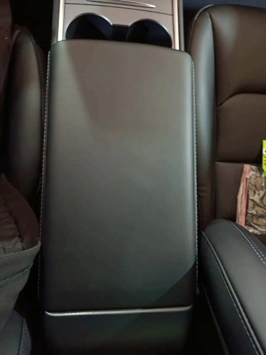 Vue rapprochée de l'accoudoir central en cuir noir de la Tesla Model 3 Grande Autonomie 2022.