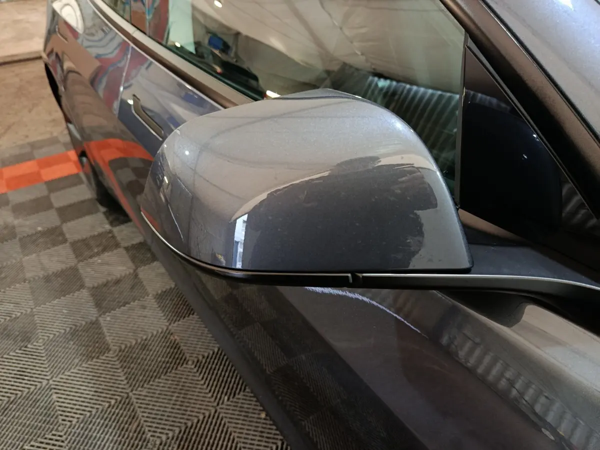 Rétroviseur côté conducteur gris foncé de la Tesla Model 3 Grande Autonomie 2022, vue rapprochée en angle avant gauche.