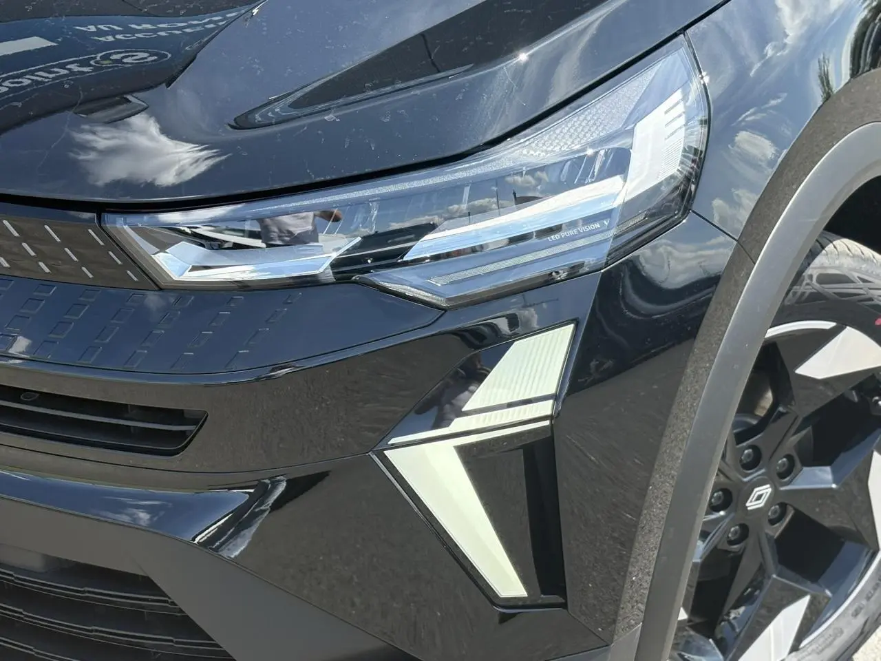 Gros plan sur l'avant droit du Renault Captur noir étoile 2025, mettant en valeur les phares LED Pure Vision et la jante aluminium.