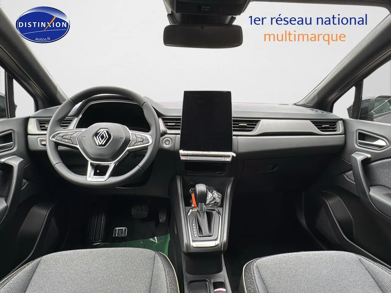 Intérieur avant du Renault Captur gris cassiopée, vue centrée sur le tableau de bord et le volant multifonction.