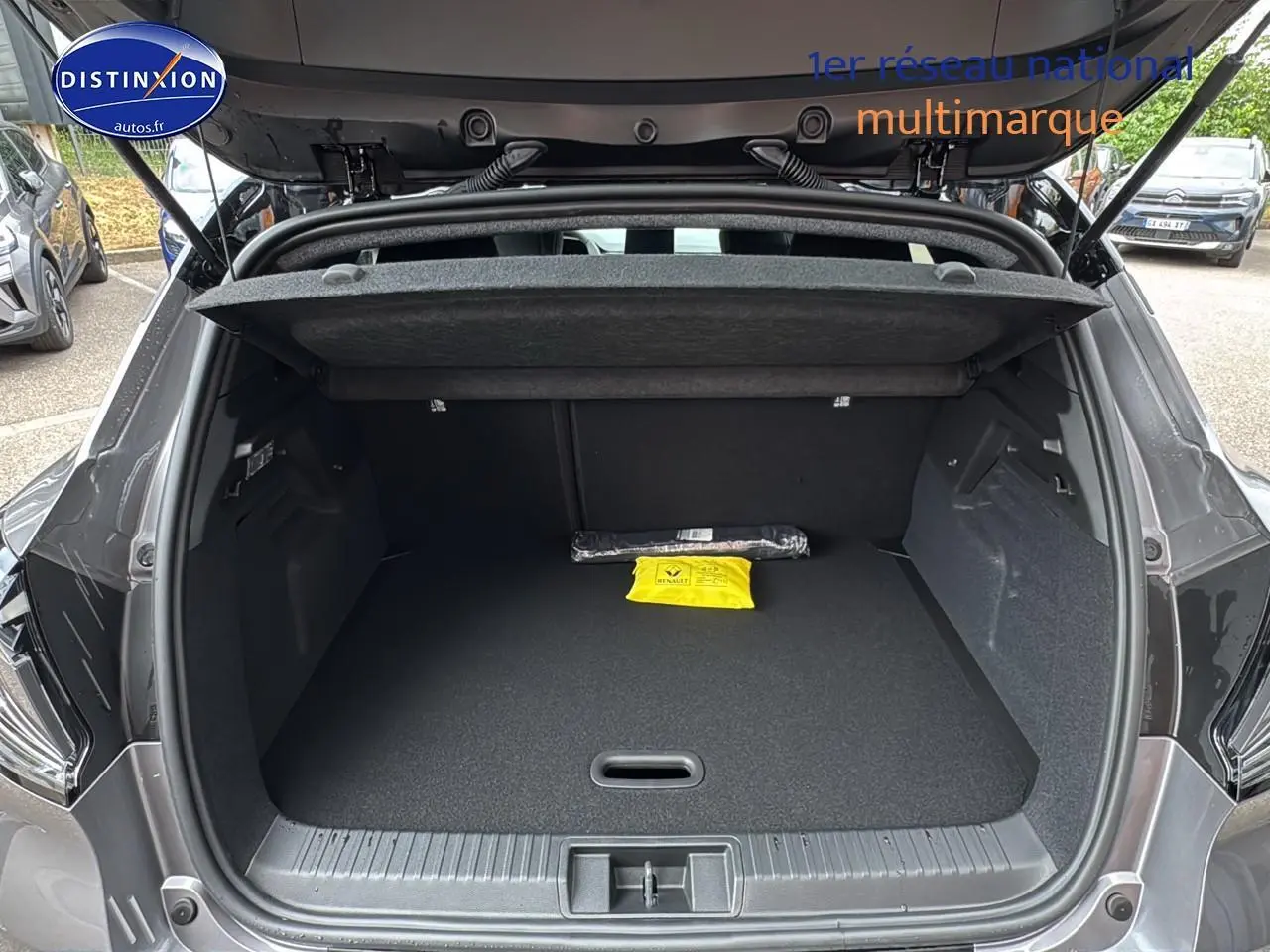 Coffre ouvert d'un Renault Captur gris cassiopée, vue arrière montrant l'espace de chargement vide avec cache-bagages.