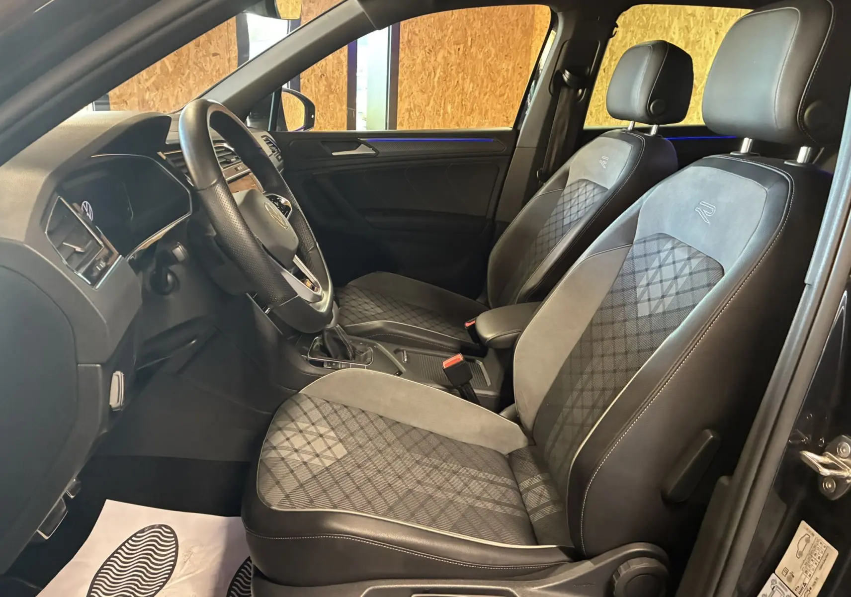 Intérieur noir du Volkswagen Tiguan 2.0 TDI 2022, vue côté conducteur, sièges sport R-Line en tissu et cuir.