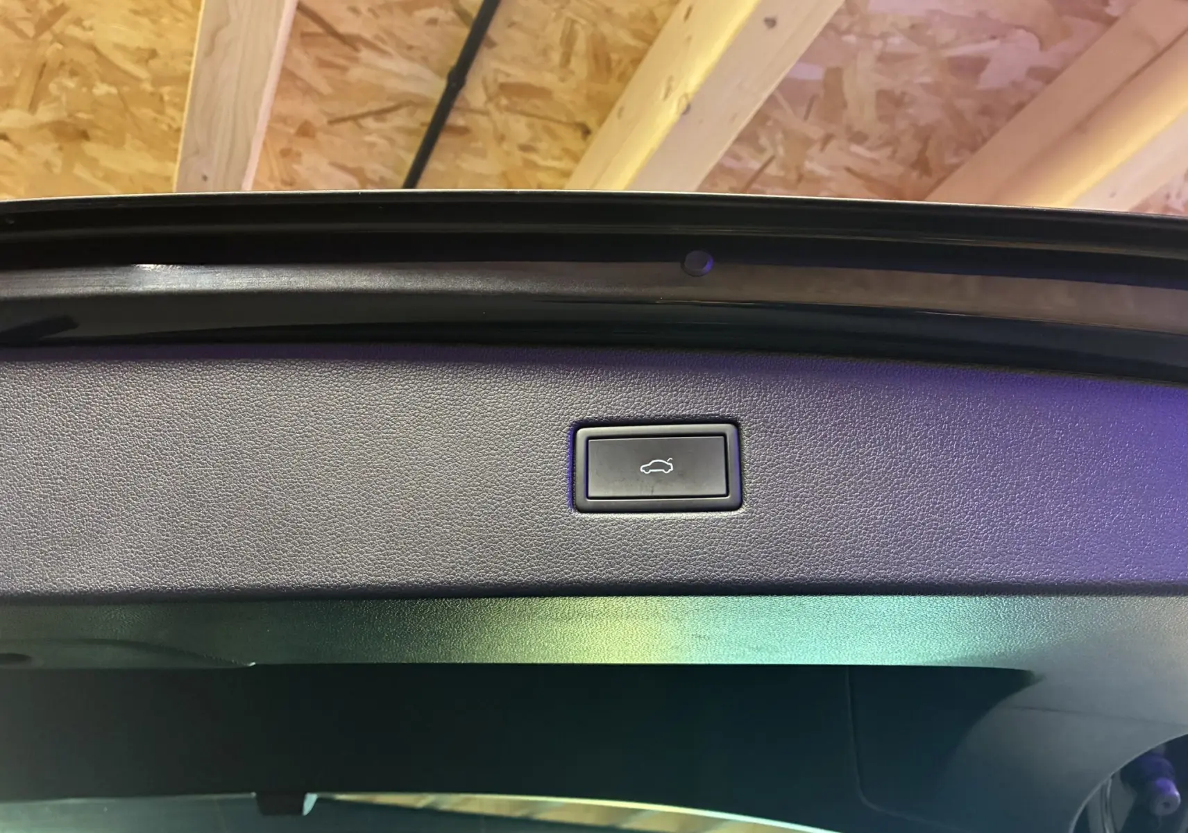 Bouton d'ouverture électrique du hayon sur la partie intérieure du coffre d'un Volkswagen Tiguan noir 2022.