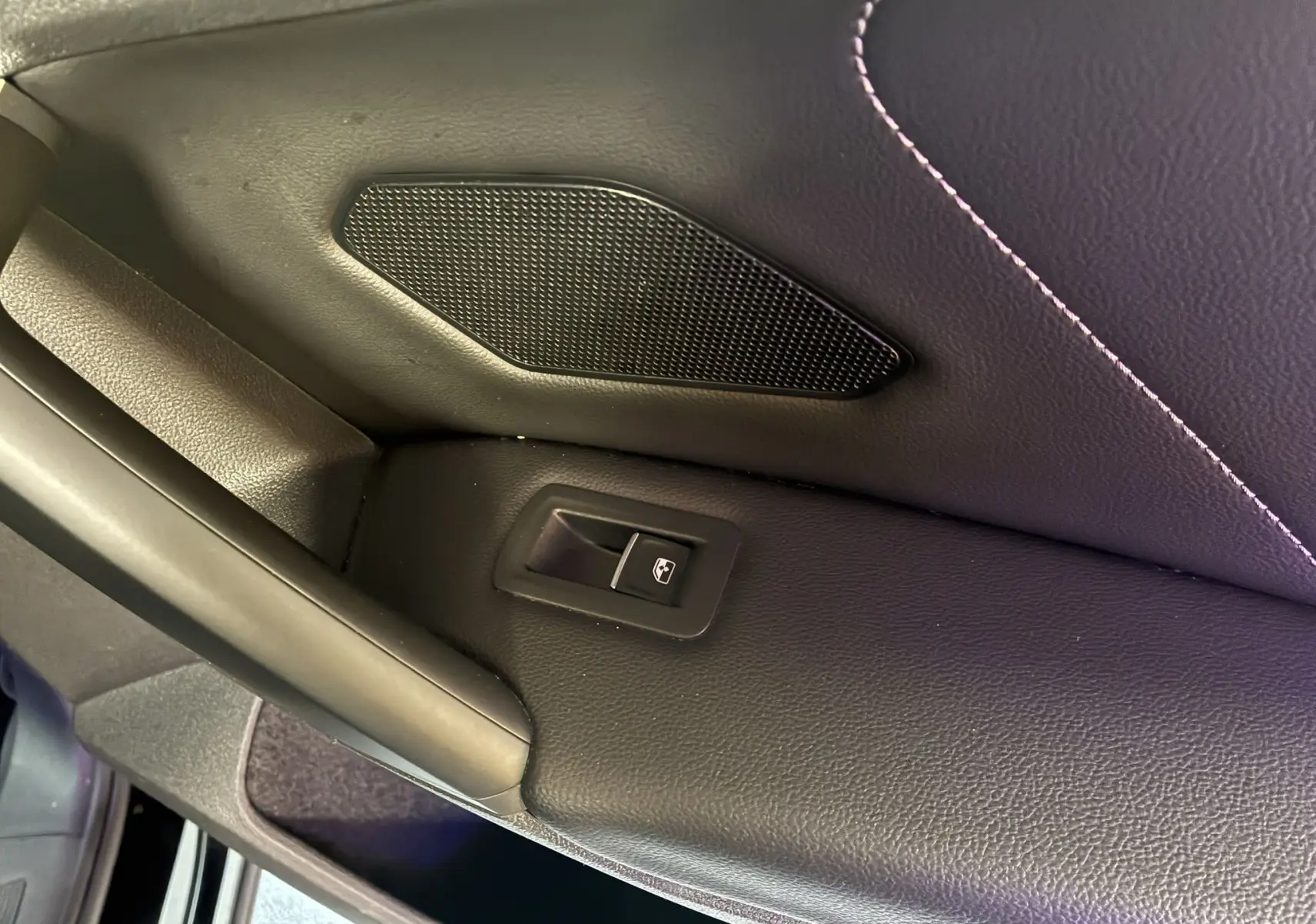 Détail de la commande de lève-vitre arrière sur la porte intérieure noire du Volkswagen Tiguan 2022.