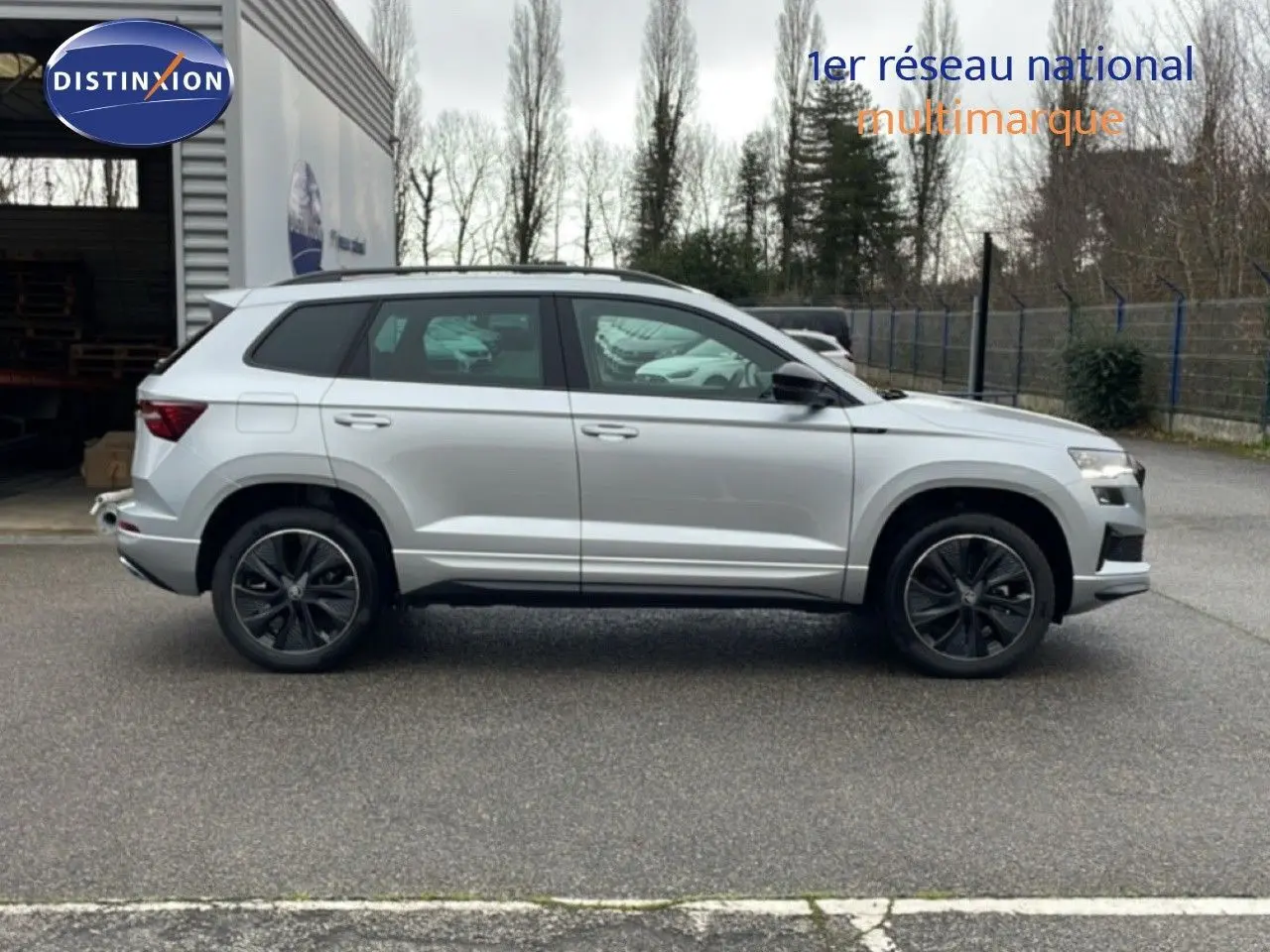 Profil droit d’un Skoda Karoq gris argent métallisé 2025, version Sportline avec jantes noires et détails sportifs.