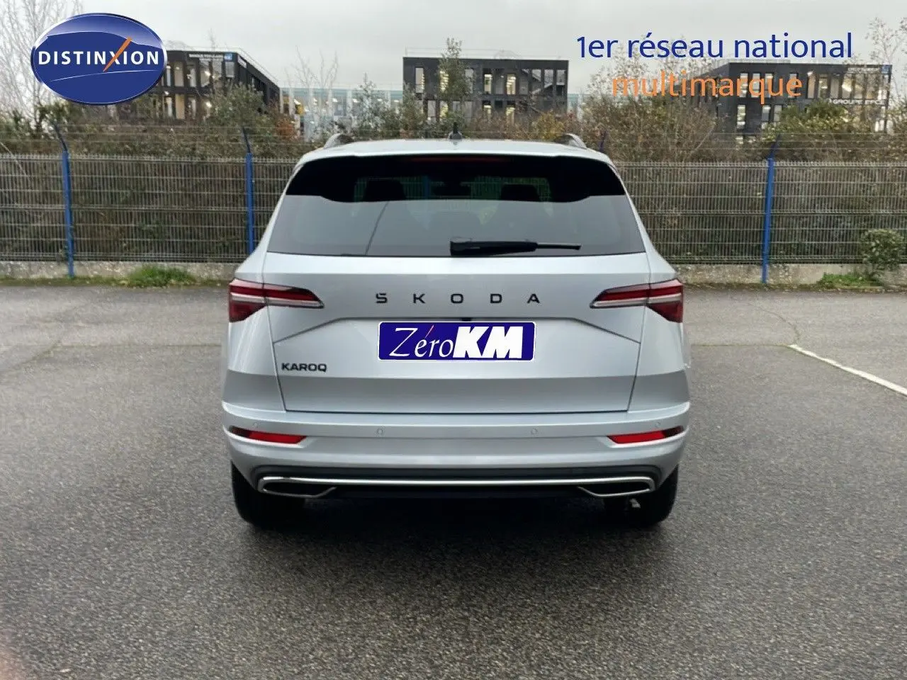 Vue arrière d'un Skoda Karoq gris argent métal 2025, avec feux LED et double sortie d'échappement intégrée.