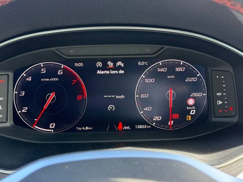 Tableau de bord numérique du SEAT Arona 2025 affichant tachymètre, compteur de vitesse et alertes, vue frontale rapprochée.