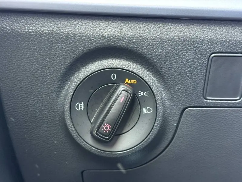 Commande rotative des feux avec mode automatique, située sur le tableau de bord noir du SEAT Arona 2025.