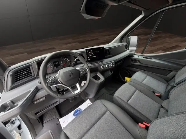 Vue intérieure côté conducteur du Renault Master blanc 2025, tableau de bord moderne avec écran tactile central.