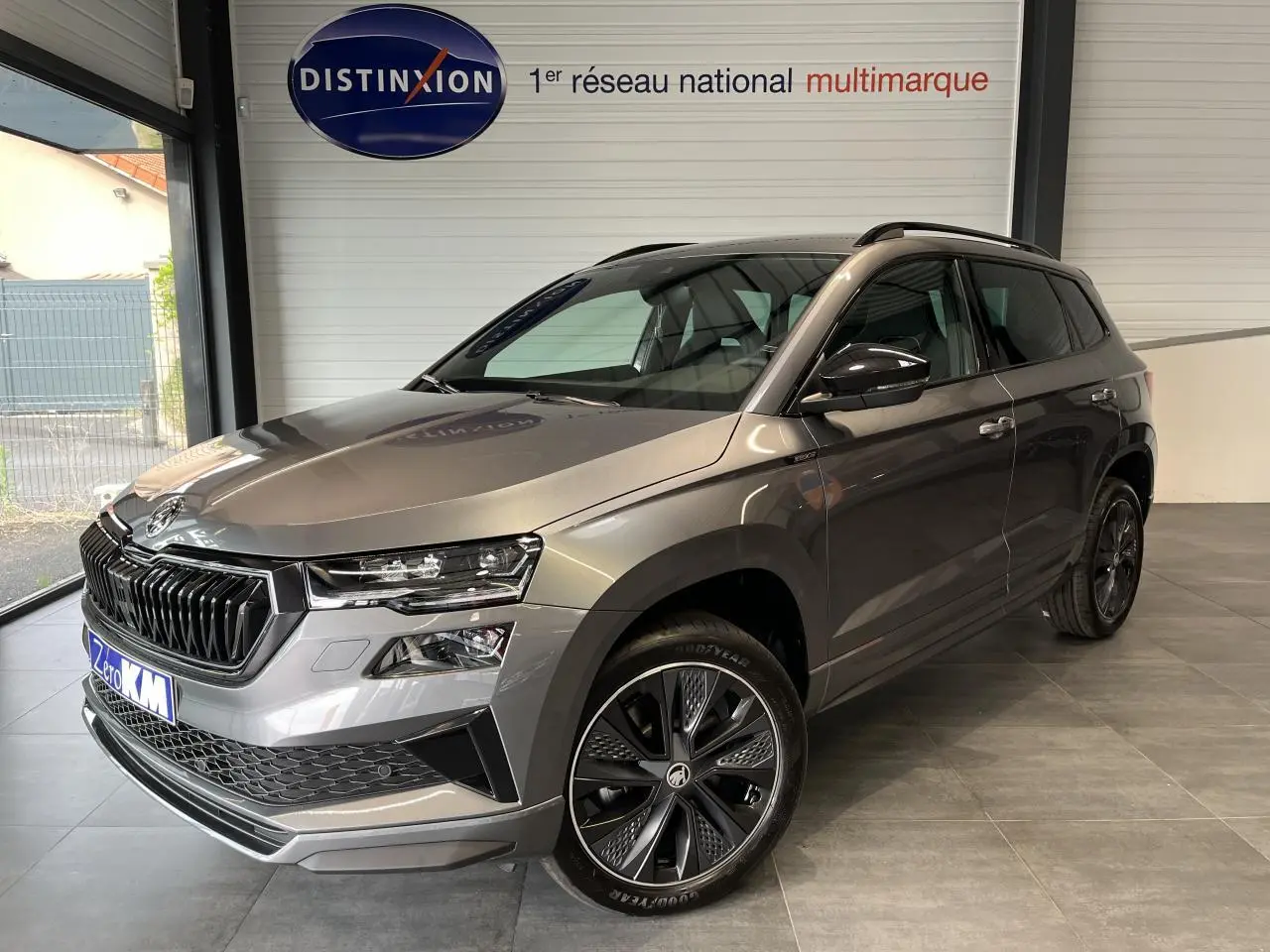 SKODA KAROQ gris perle en 3/4 avant droit avec jantes alliage 19'' Sagitarius anthracite et calandre noire sportive.
