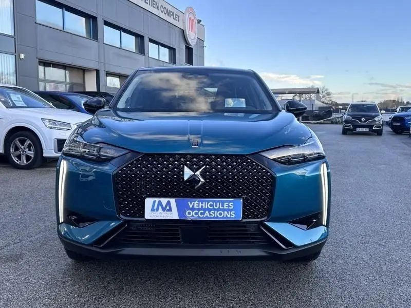 Vue frontale d'une DS3 1.2 Hybride 145 Étoile bleu métal, avec calandre noire à motif losange et feux LED verticaux.