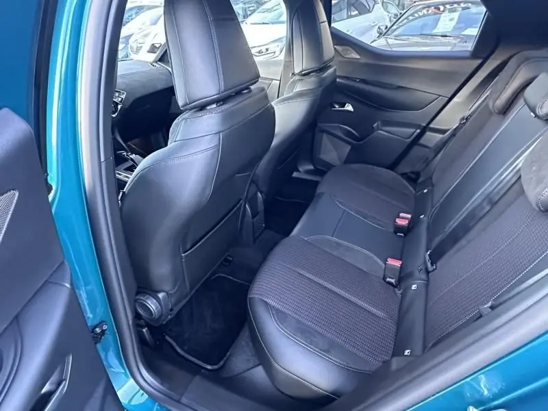 Vue intérieure arrière côté gauche du DS3 2025 bleu métal, montrant les sièges arrière en tissu et cuir noir.