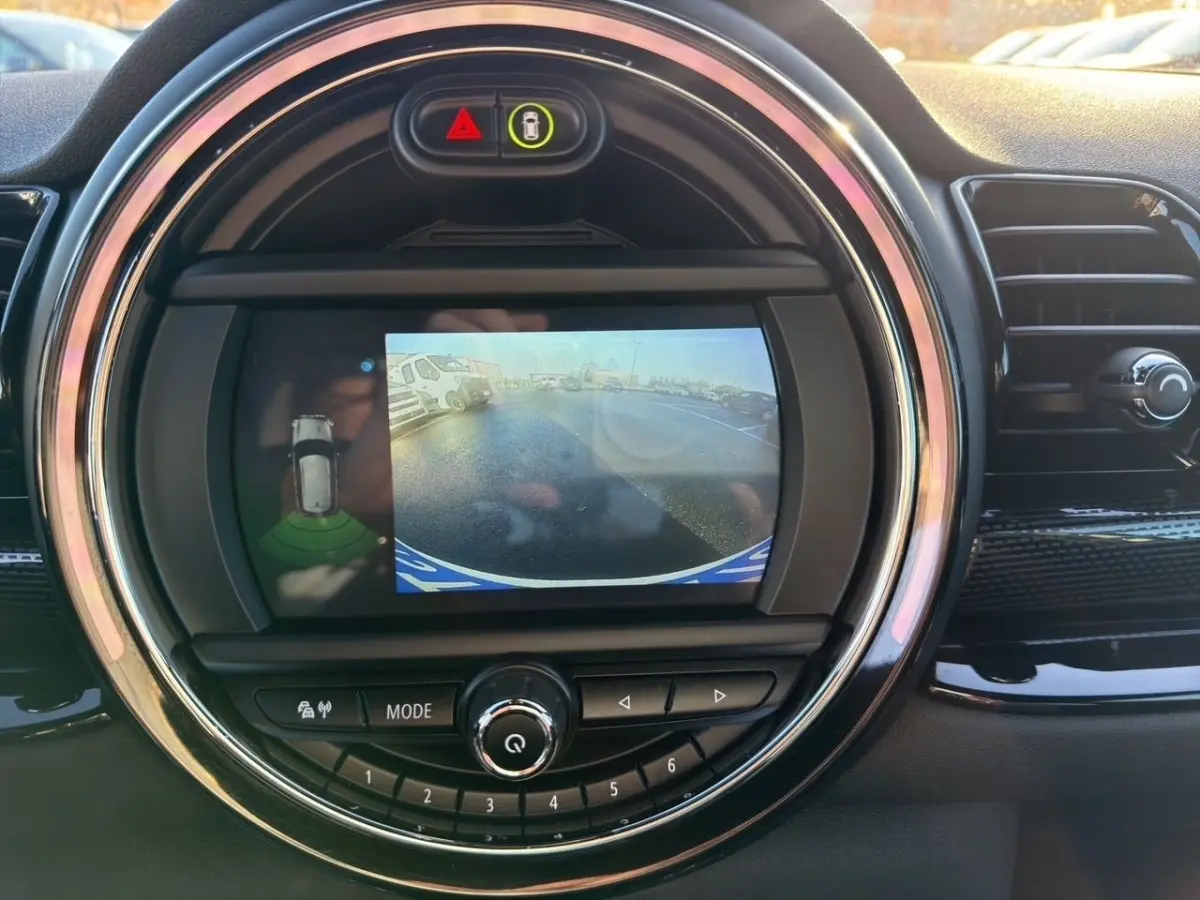 Écran tactile central affichant la caméra de recul dans l’habitacle noir d’une MINI Clubman blanche.