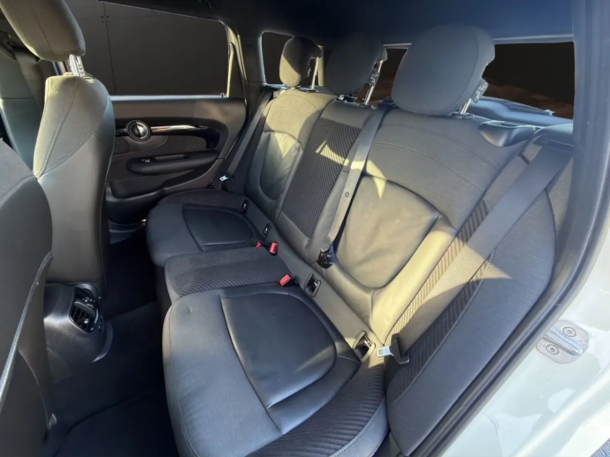 Vue intérieure côté droit des sièges arrière noirs en tissu et cuir d'une MINI Clubman F54 blanche.
