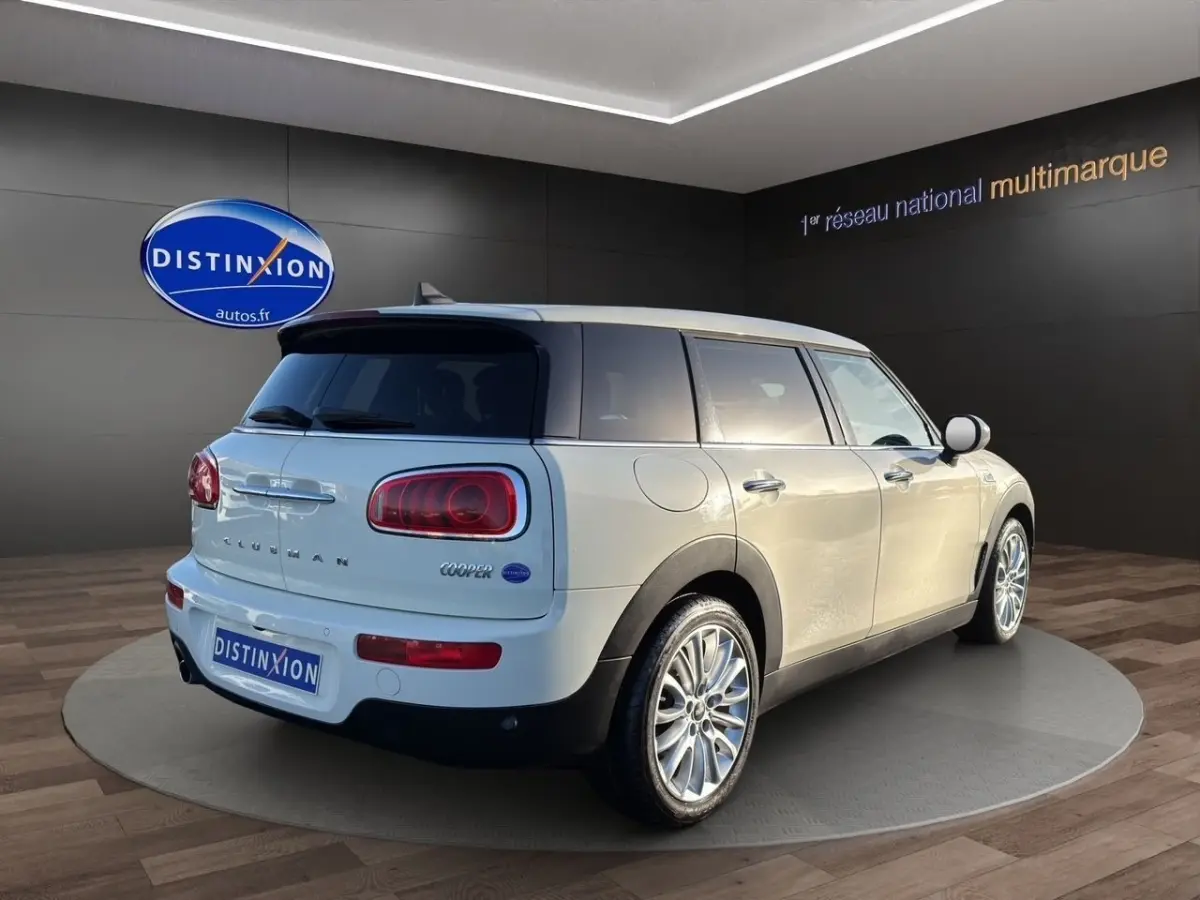 Vue 3/4 arrière droite d'une MINI Clubman Cooper Exquisite blanche avec jantes alliage et feux arrière LED.