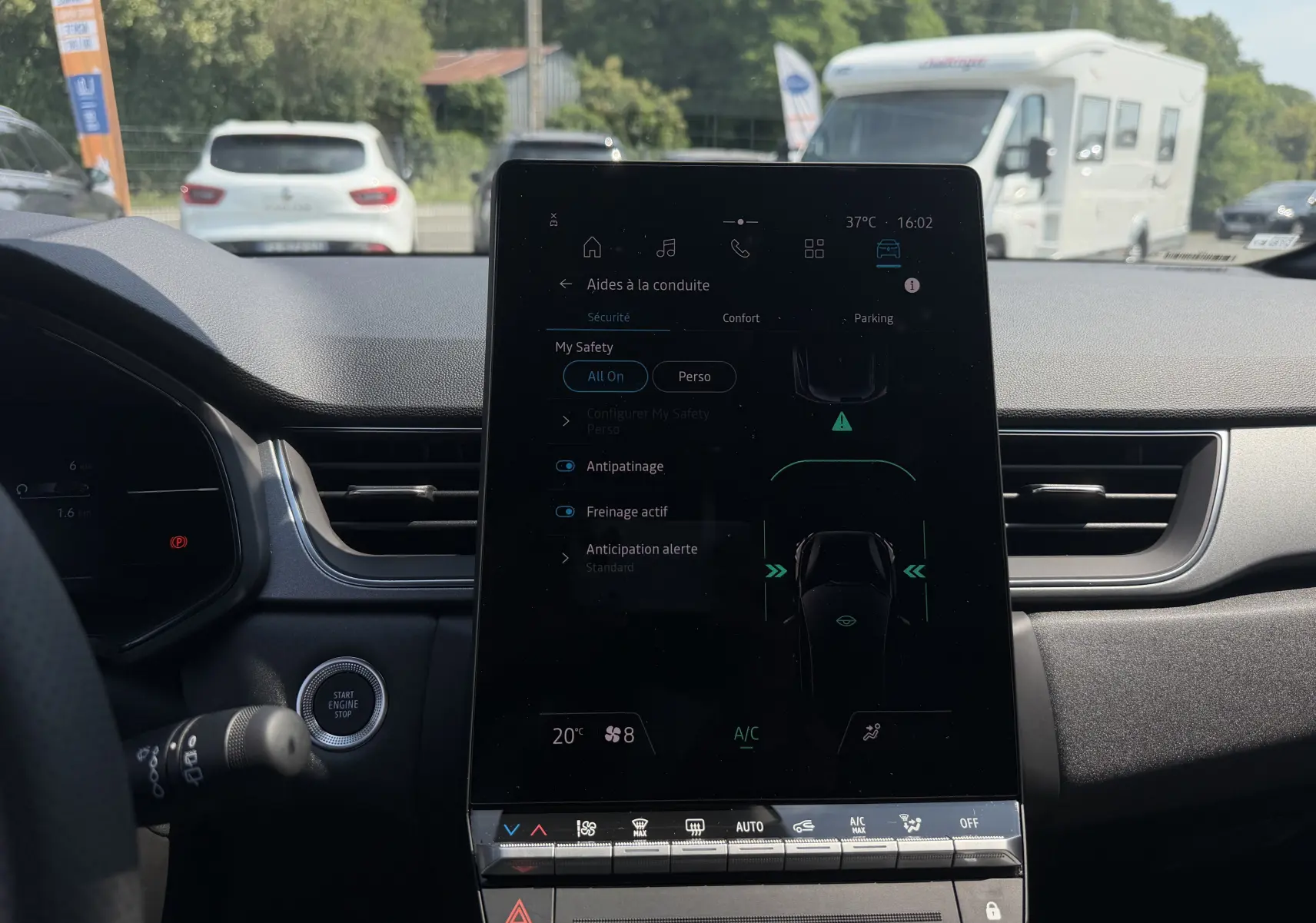 Vue intérieure centrée sur l’écran tactile vertical du tableau de bord du Renault Captur gris Cassiopée bi-ton, affichant les aides à la conduite.